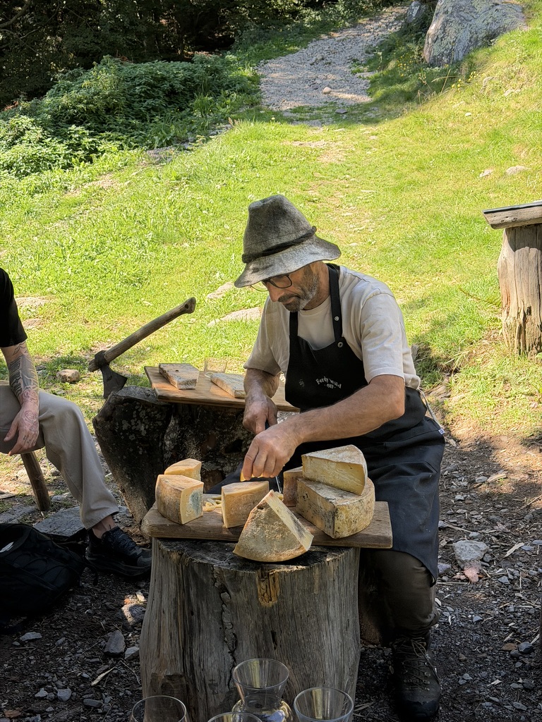 Un casaro taglia il formaggio su un ceppo di legno