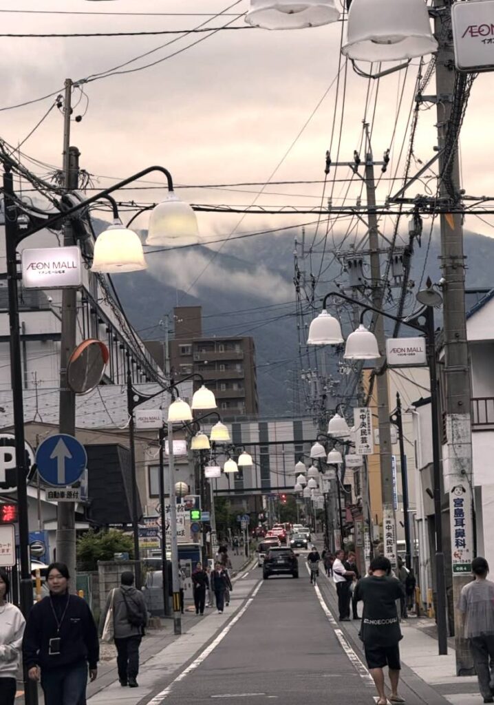 Una via del centro di Matsumoto con le montagne sullo sfondo